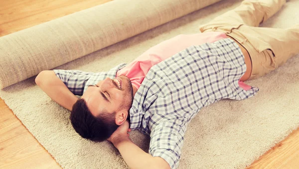 Hombre feliz acostado alfombra o alfombra en casa — Foto de Stock