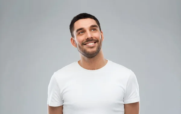 Uomo sorridente guardando su sfondo grigio — Foto Stock