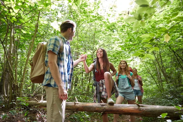 Groep lachende vrienden met rugzakken wandelen — Stockfoto