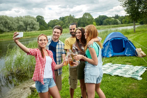 Amigos felices tomando selfie por teléfono inteligente en el campamento —  Fotos de Stock