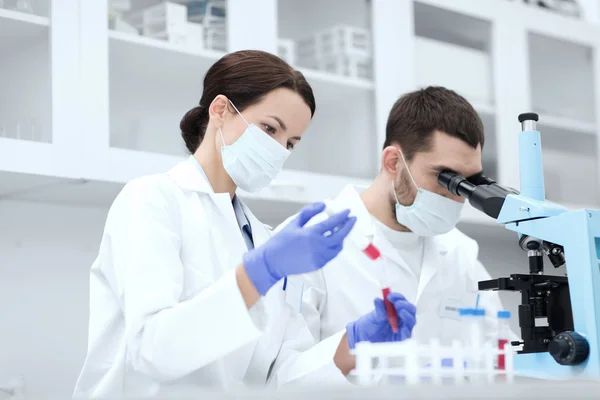 Jóvenes científicos haciendo pruebas o investigaciones en laboratorio —  Fotos de Stock