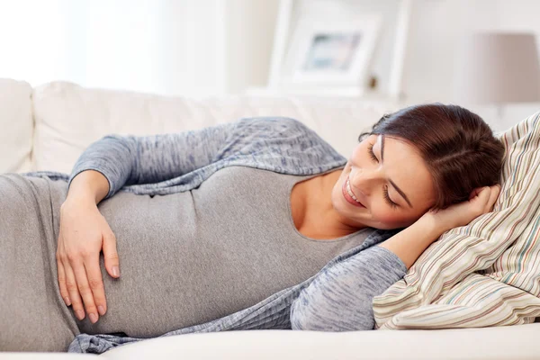 Gelukkig zwanger vrouw liggend op bank thuis — Stockfoto