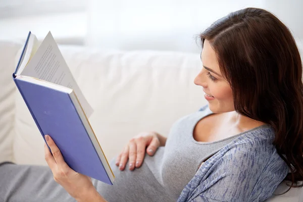 Ευτυχισμένη έγκυος γυναίκα ανάγνωση του βιβλίου στο σπίτι — Φωτογραφία Αρχείου