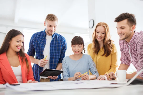 Creative team with blueprint working at office — Stock Photo, Image