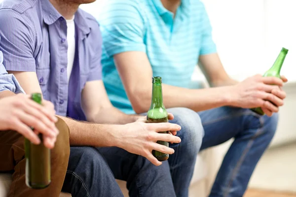 Happy male friends drinking beer at home — Stock fotografie