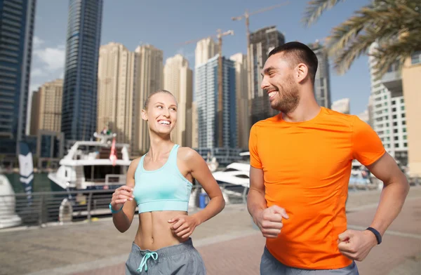 Pareja corriendo sobre dubai ciudad calle fondo — Foto de Stock