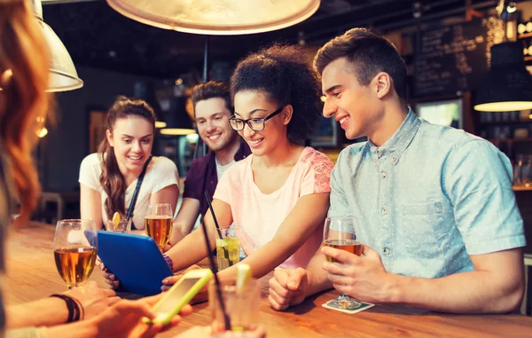 Amis heureux avec tablette pc et boissons au bar — Photo