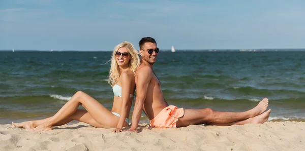 Felice coppia in costume da bagno seduto sulla spiaggia estiva — Foto Stock