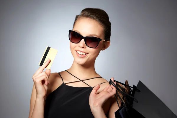 Mujer feliz con tarjeta de crédito y bolsas de compras — Foto de Stock