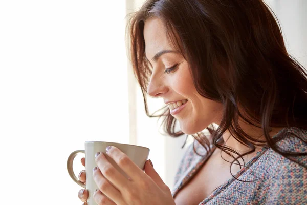 Mujer feliz con taza de té o café en casa —  Fotos de Stock