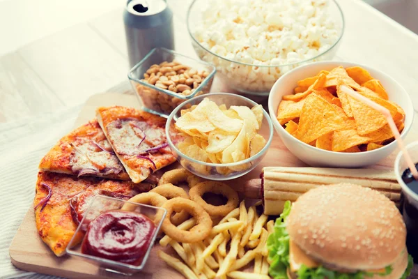 Close up of fast food snacks and drink on table — Stock Photo, Image