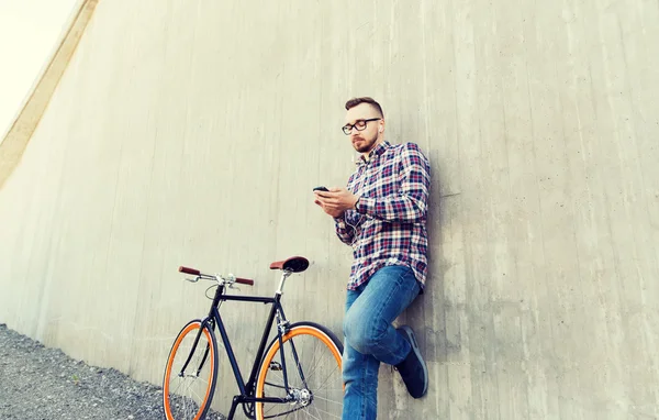 Homem hipster em fones de ouvido com smartphone e bicicleta — Fotografia de Stock