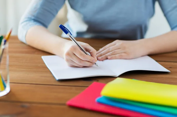 Close up of student writing to notebook at home — Stock Photo, Image