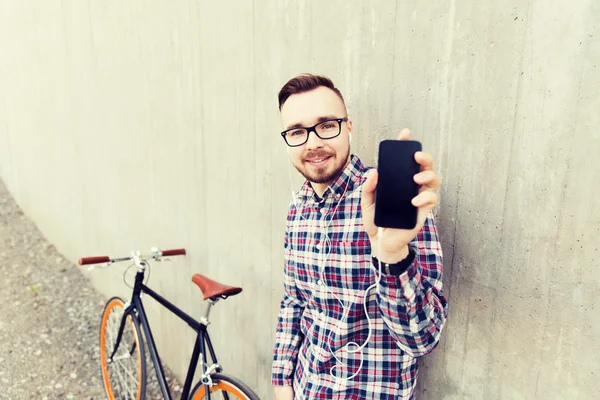 Hipster man in earphones with smartphone and bike — Stock Photo, Image