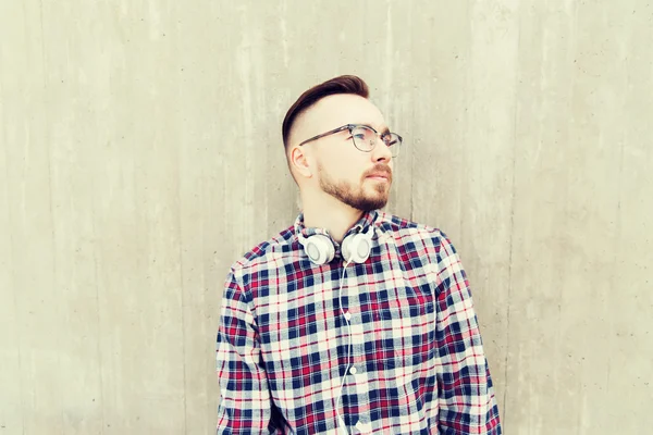 Happy young hipster man with headphones over wall — Stock Photo, Image