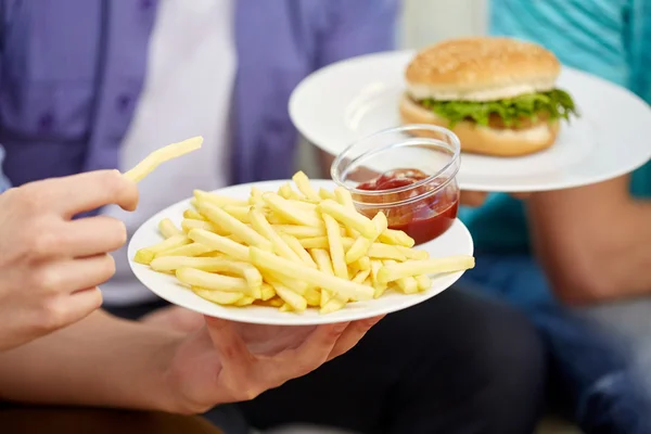 Bliska męskich rąk z fast food na płyty — Zdjęcie stockowe