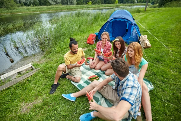 Amici felici mangiare anguria in campeggio — Foto Stock