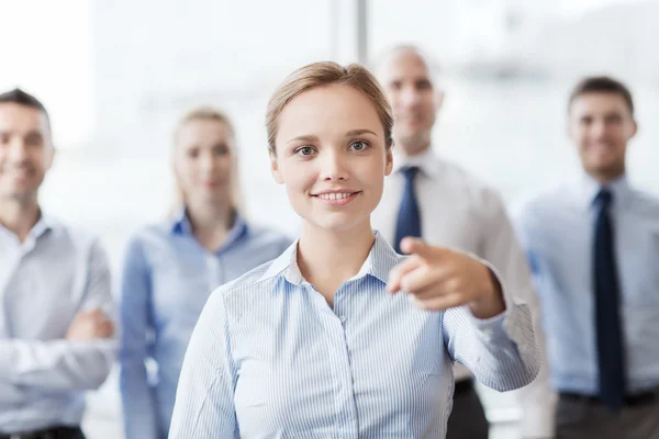 Sorridente empresária apontando dedo em você — Fotografia de Stock