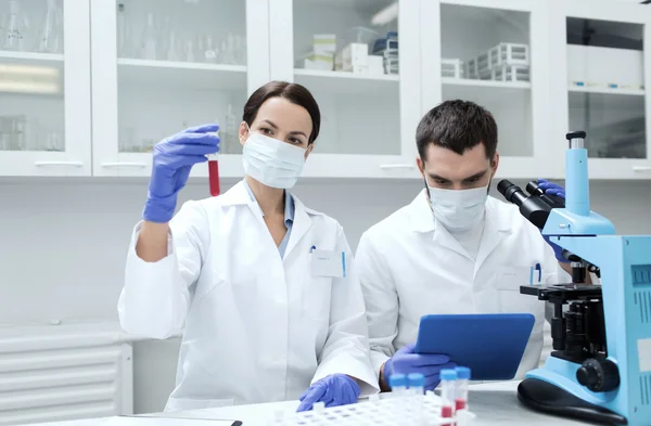 Jovens cientistas que fazem testes ou pesquisas em laboratório — Fotografia de Stock