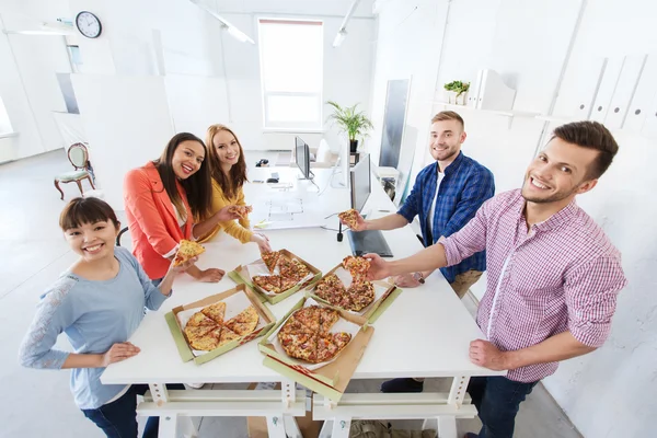 Šťastný obchodní tým jíst pizzu v úřadu — Stock fotografie