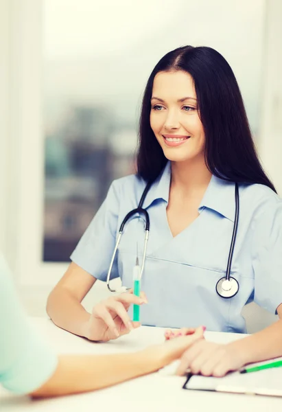 Улыбающаяся женщина-врач или медсестра со шприцем — стоковое фото