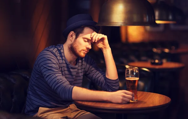 Unhappy lonely man drinking beer at bar or pub — Stock Photo, Image