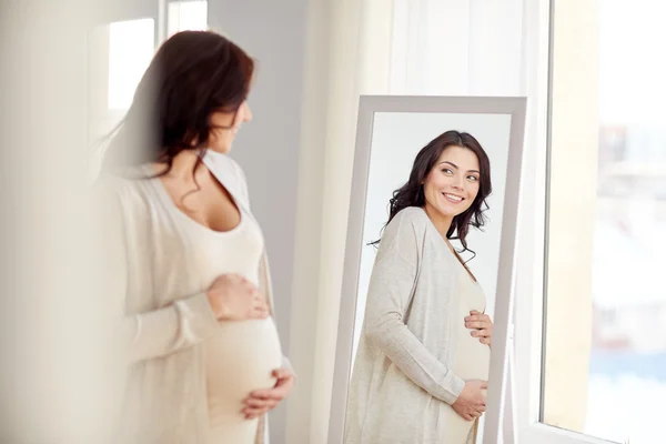 Happy pregnant woman looking to mirror at home — Stock Photo, Image
