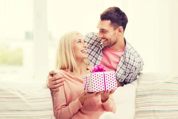 Happy man giving woman gift box at home — Stock Photo, Image