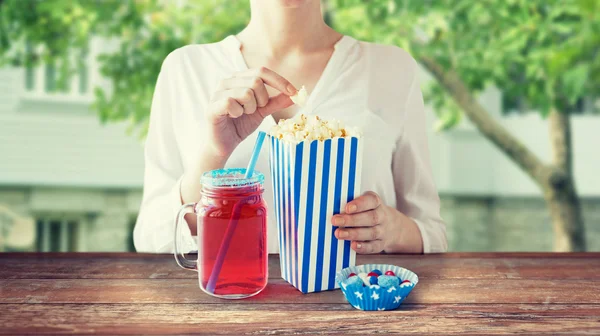 Žena jíst popcorn s nápojem v mason sklenice — Stock fotografie