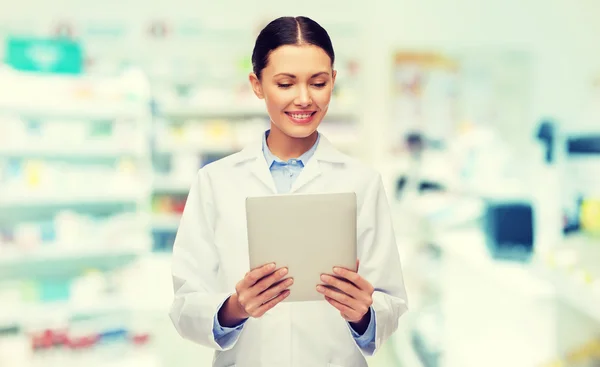 Doctora sonriente con tableta pc en la farmacia — Foto de Stock
