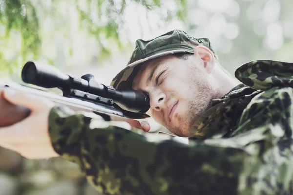 Mladý voják nebo lovec s pistolí v lese — Stock fotografie