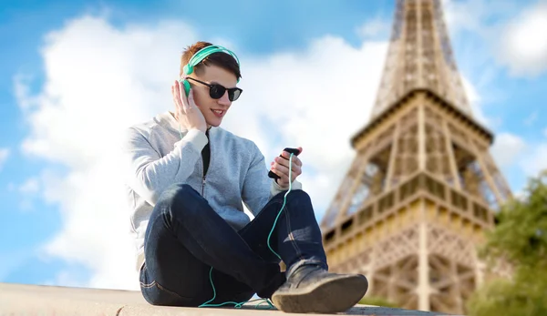 Jovem feliz em fones de ouvido com smartphone — Fotografia de Stock