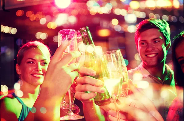 Amis souriants avec des verres à vin et de la bière en club — Photo