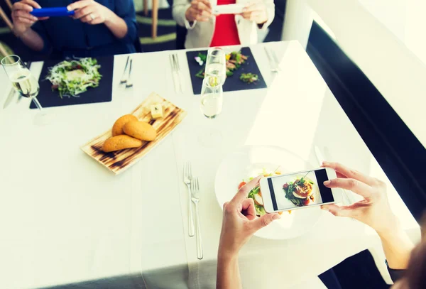 Close up de mulheres imaginando comida por smartphones — Fotografia de Stock