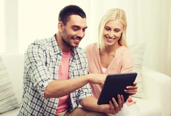 Souriant couple heureux avec tablette PC à la maison — Photo