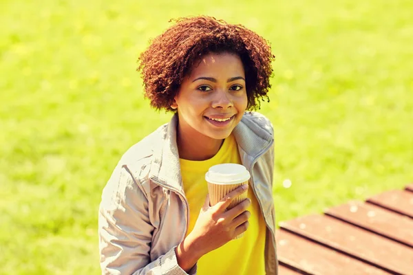 Sorrindo mulher africana bebendo café ao ar livre — Fotografia de Stock