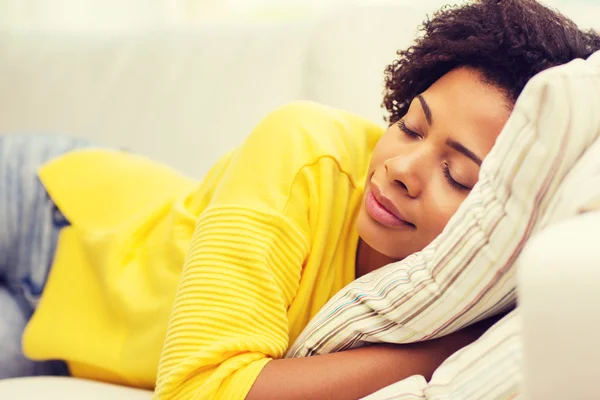 Mujer joven africana durmiendo en el sofá en casa —  Fotos de Stock