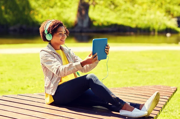 Gelukkig Afrikaanse vrouw met tablet pc en hoofdtelefoon — Stockfoto