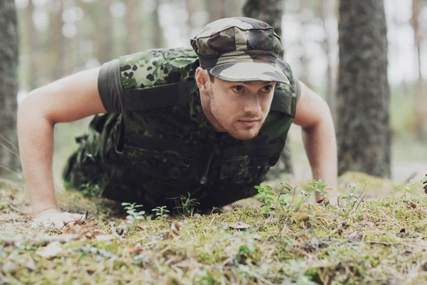Młody żołnierz lub ranger robi pompki w lesie — Zdjęcie stockowe