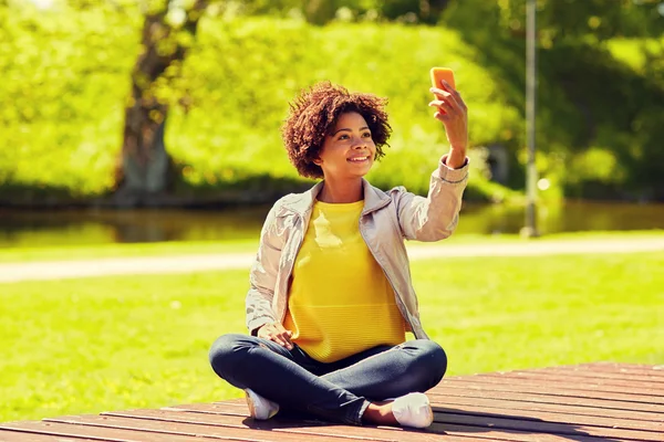 Happy african woman taking selfie with smartphone — Stock Photo, Image