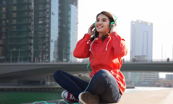 Gelukkig jonge vrouw in koptelefoon luisteren naar muziek — Stockfoto