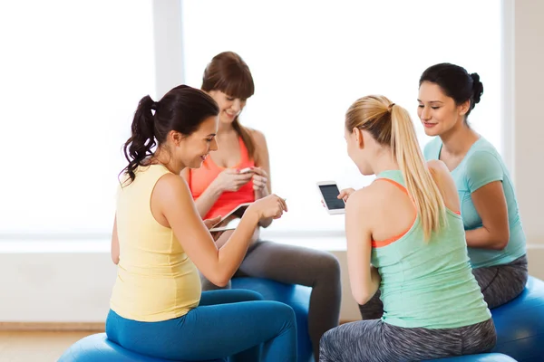 Femmes enceintes heureuses avec des gadgets dans la salle de gym — Photo