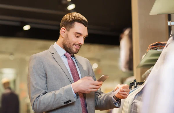 Smartphone vasıl giyim mağazası ile takım elbiseli adam — Stok fotoğraf