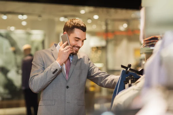 Gelukkig man opgeroepen smartphone bij kledingwinkel — Stockfoto