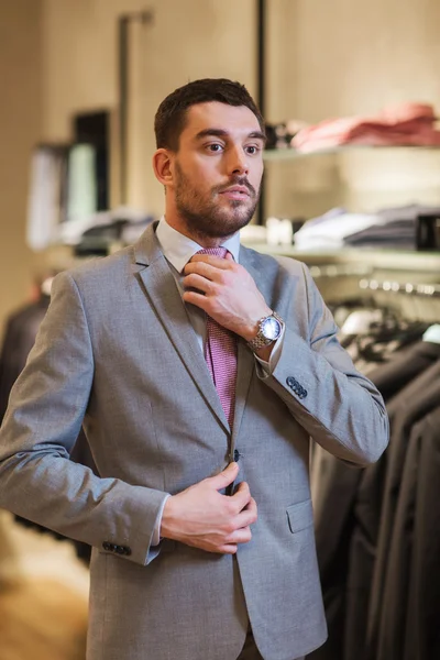 Jonge man probeert pak op in kledingwinkel — Stockfoto