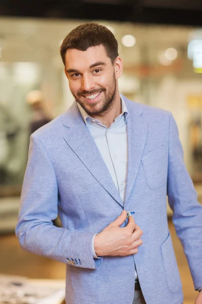 Happy young man in jacket at clothing store — Stock Photo, Image