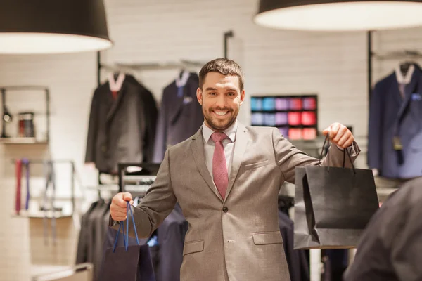 Glücklicher Mann mit Einkaufstaschen im Bekleidungsgeschäft — Stockfoto