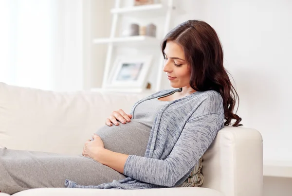 幸せな妊婦さんが家でソファに横になって — ストック写真