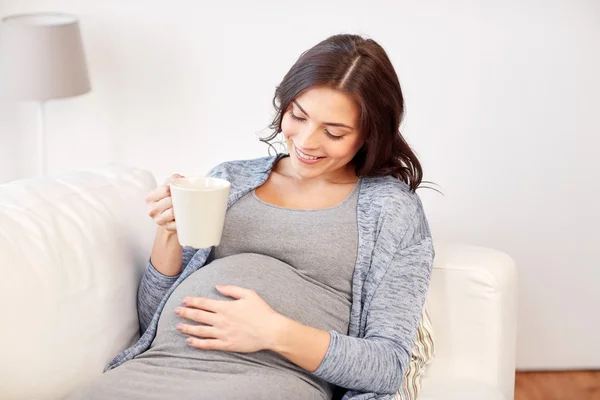 Gelukkig zwangere vrouw met kop thee drinken thuis — Stockfoto