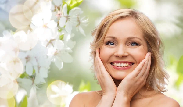 Lächelnde Frau mit nackten Schultern, die das Gesicht berührt — Stockfoto